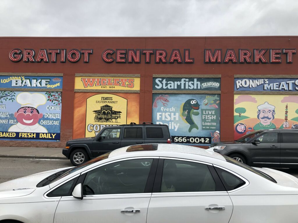 The outside of Gratiot Central Market, with murals of Ronnie's Meats, Starfish Seafood, Louanna's Bake Shoppe and Wigleys 