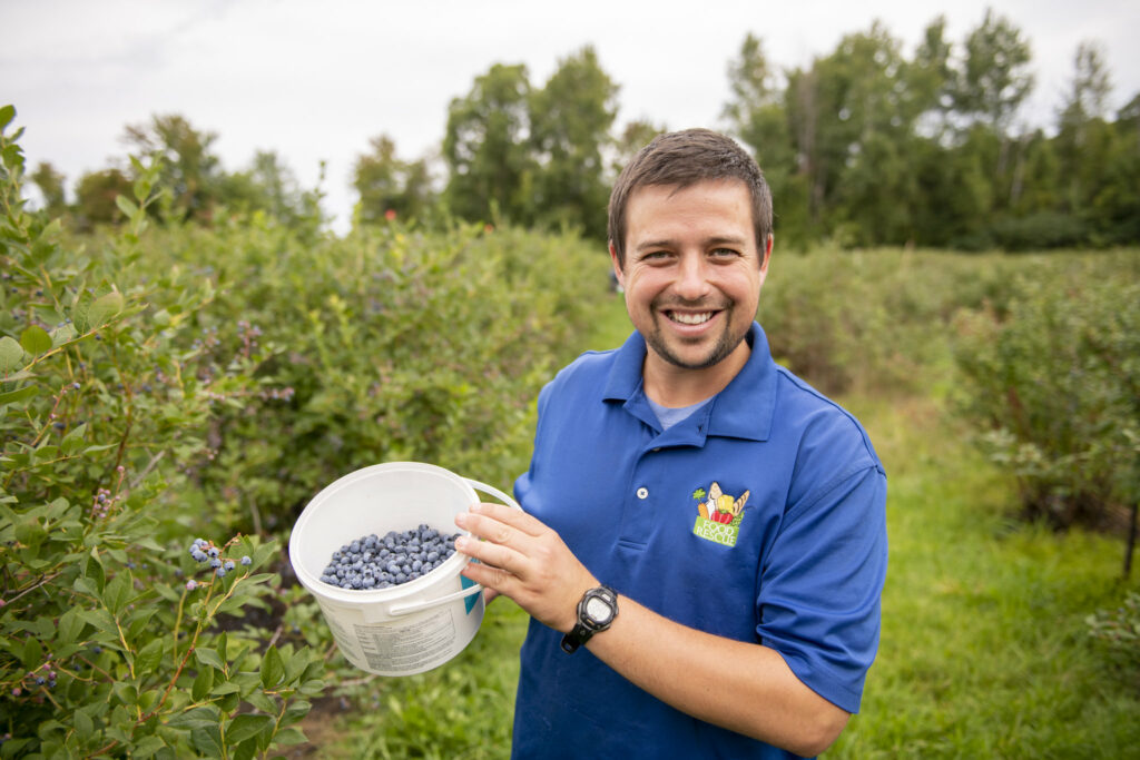 Taylor Moore of Food Rescue gleans blueberries in Northern Michigan
