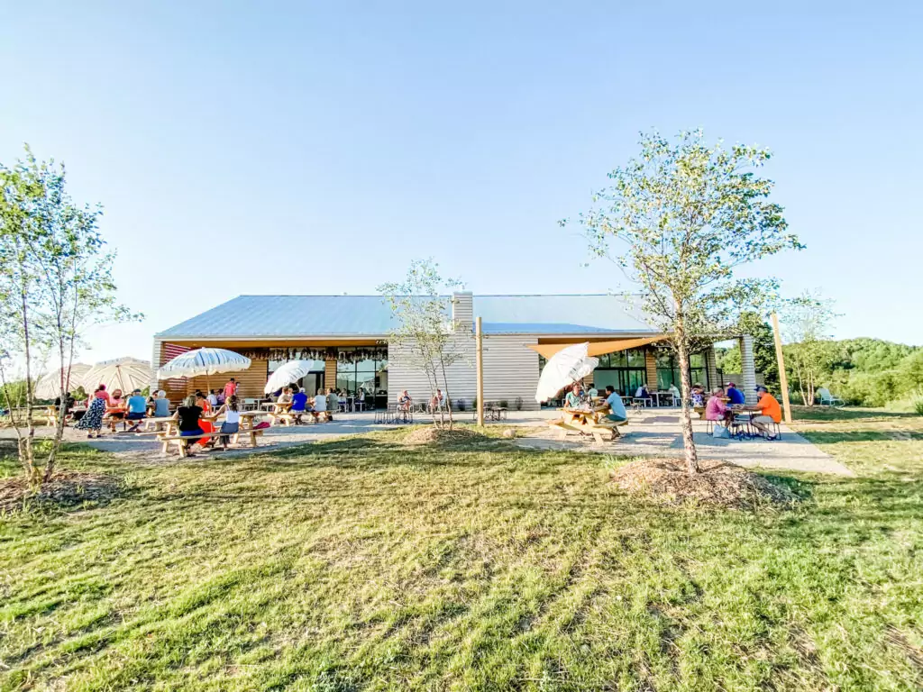 Farm Club in the summer, with customers sat in picnic tables with umbrellas. Photo Credit: Camille Hoisington